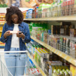 mulher lendo o rótulo de um produto no mercado